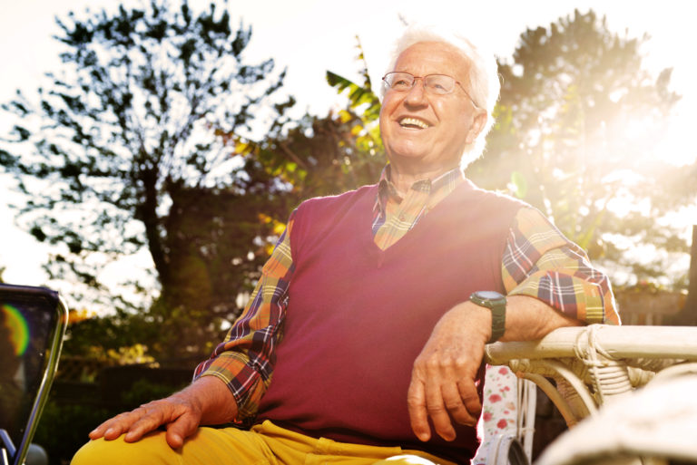 health care costs. Elderly man sitting in yard