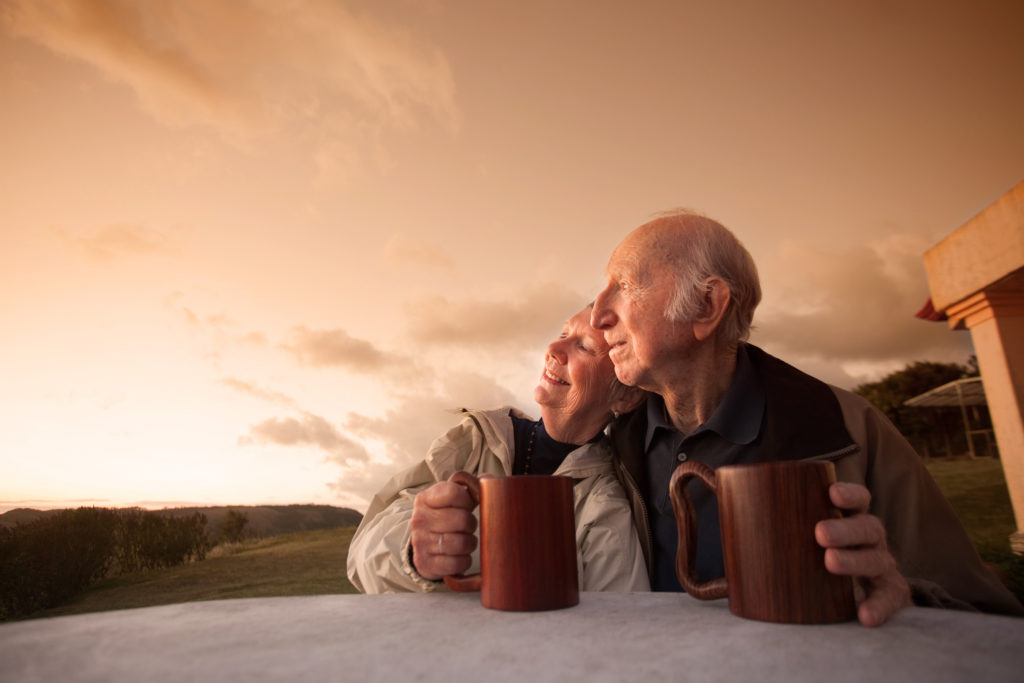 childless seniors. Smiling senior couple sitting outside at sunset