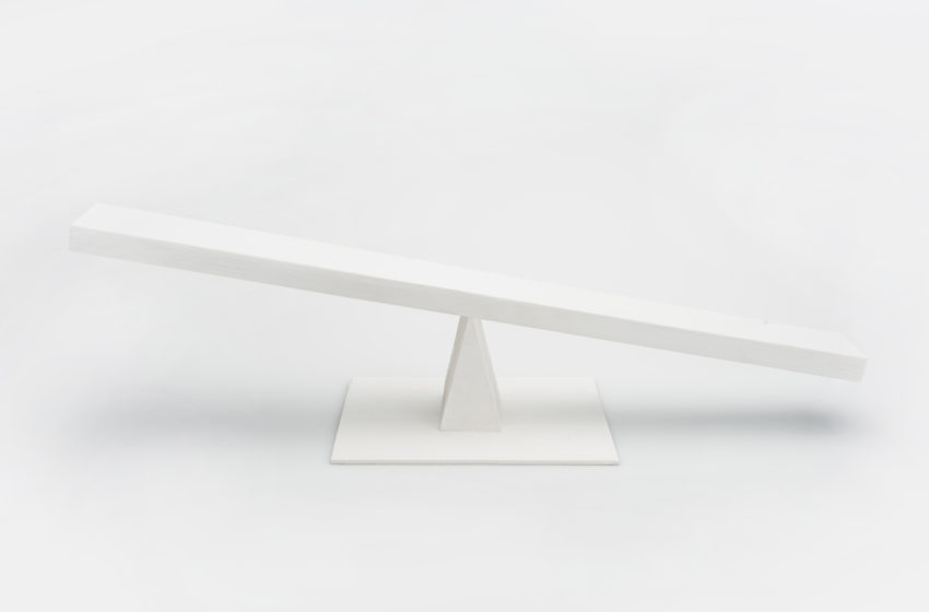 White, angled balancing scale on white background
