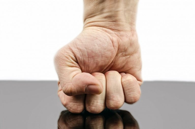 Rheumatoid arthritis: image is of hand making fist and pressing down into table