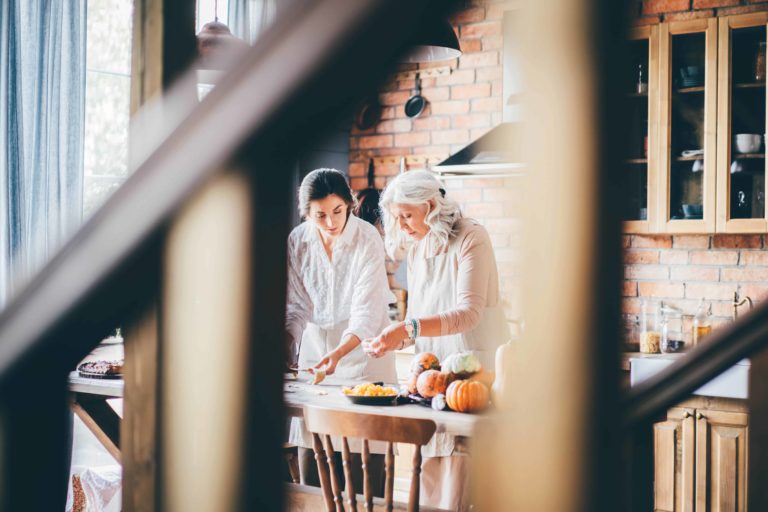 Senior mother and daughter cooking together family recipes