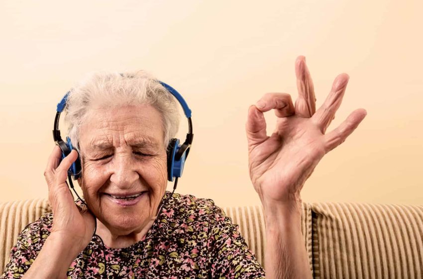 Senior woman listening to music with headphones. Changing the culture of aging.