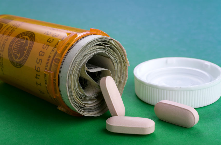 Healthcare concept: Money filling perscription bottle with only a few pills spilling out. Represents rising cost in healthcare costs.