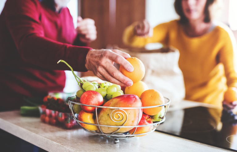 Seniors unpacking fruit in a bowl for healthy senior diet