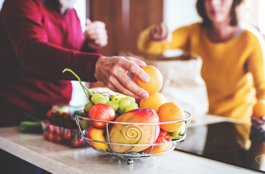 Seniors unpacking fruit in a bowl for healthy senior diet
