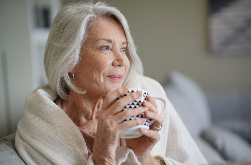 Senior with blanket and hot beverage