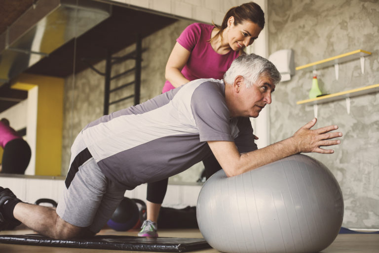 Man in physical therapy for chronic pain receiving treatment for back pain