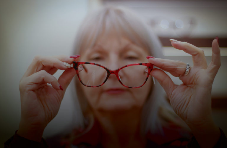 Woman examining her eyeglasses, low vision concept