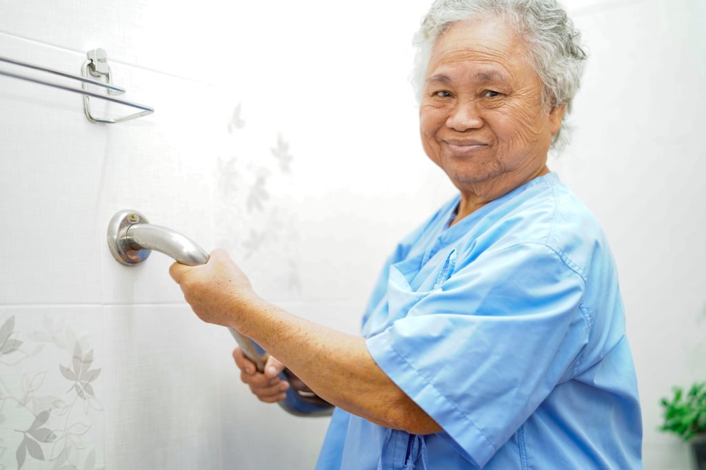 Senior woman holding grab bar in a bathroom