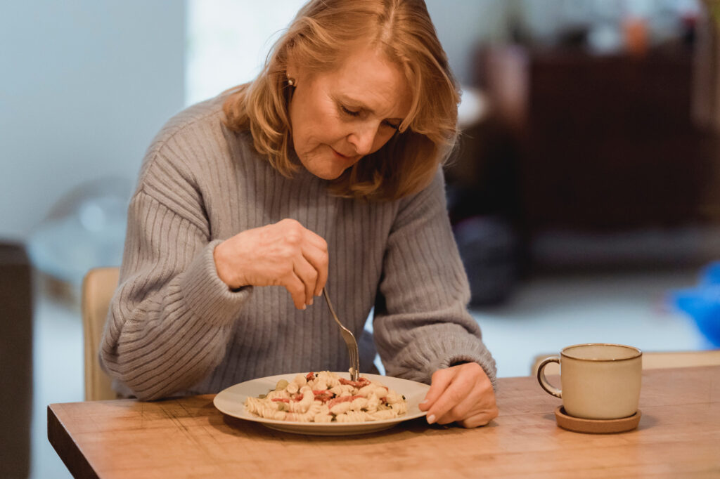 Senior woman picking at food