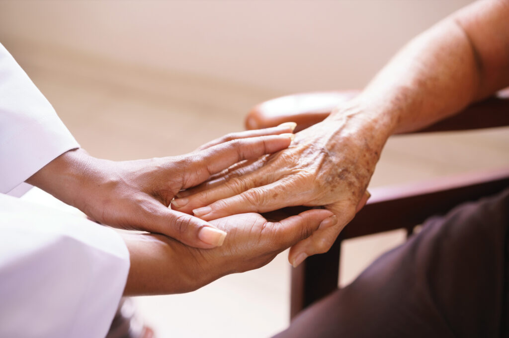 Compassionately holding the hand of a senior