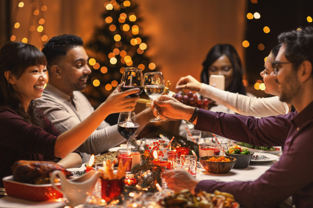 happy friends drinking wine at christmas party