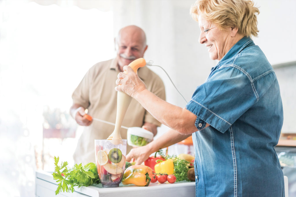 Seniors cooking nutritious food together, important for oral health