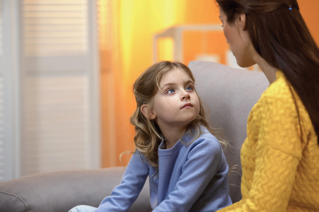 Mother talking to daughter. Explaining dementia to kids