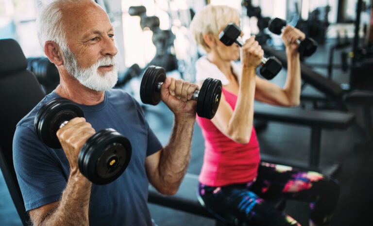 Seniors doing strength training at a gym with free weights