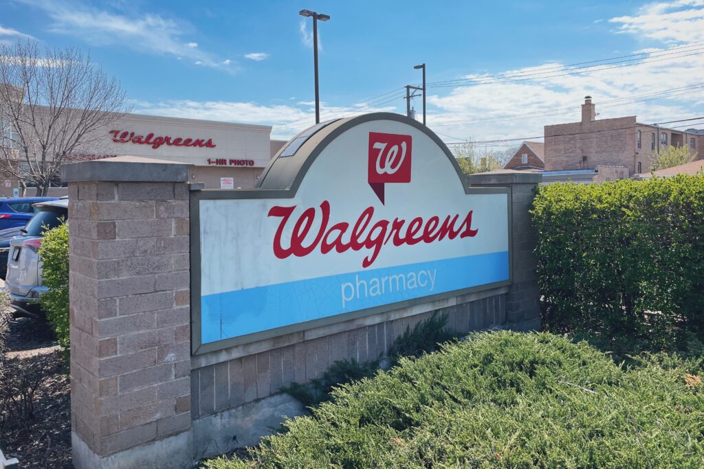 A Walgreens sign, surrounded by greenery, outside a store in Chicago