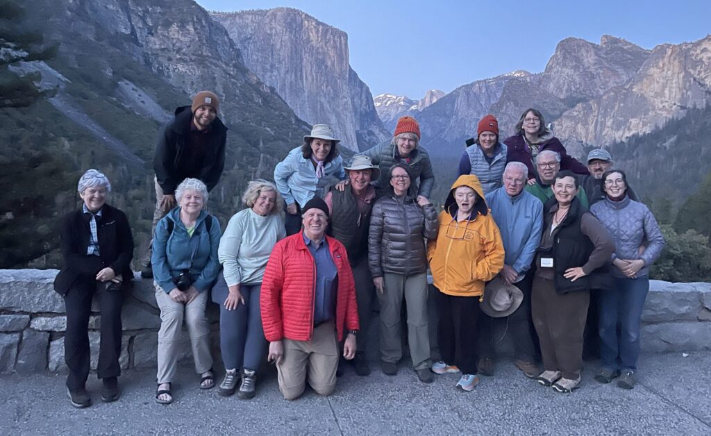 A group of travelers from Road Scholar poses for a photo at Yosemite National Park.