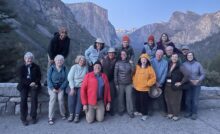 A group of travelers from Road Scholar poses for a photo at Yosemite National Park.