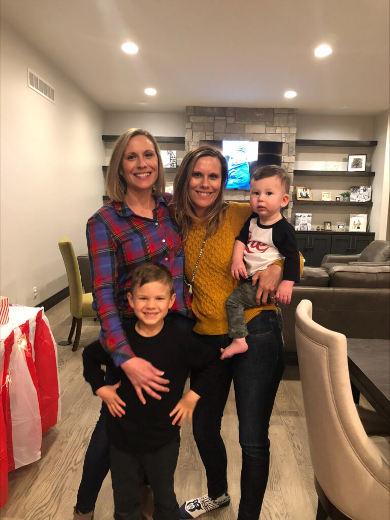 Sarah Rasby, her sister, and their children smile together for a photo.