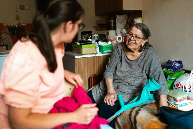 Young woman taking care of an older woman in her kitchen.